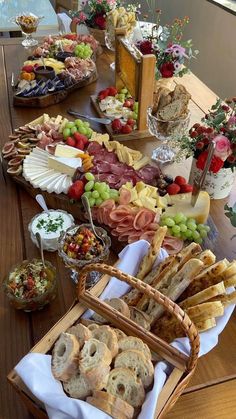 a wooden table topped with lots of different types of breads and pastries on top of it