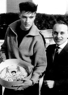 black and white photograph of two men holding a bowl