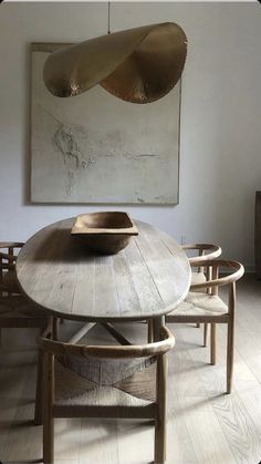 a dining room table with chairs and a painting on the wall above it that reads stockholm