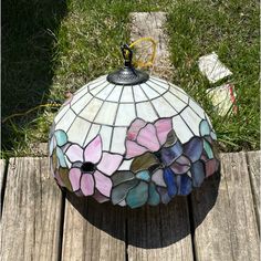 a stained glass lamp sitting on top of a wooden table