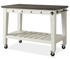 a white kitchen island with drawers and wheels