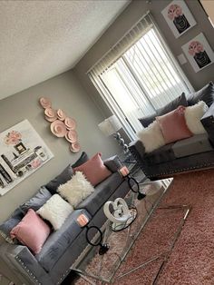 a living room with two couches and pillows on top of it's carpet