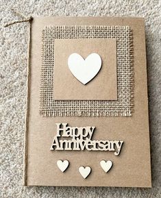 a card that says happy anniversary with hearts on the front and back, surrounded by cutouts