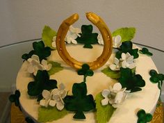 a cake decorated with white flowers and green leaves