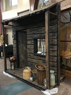 a small wooden house made out of wood and other items on display in a building