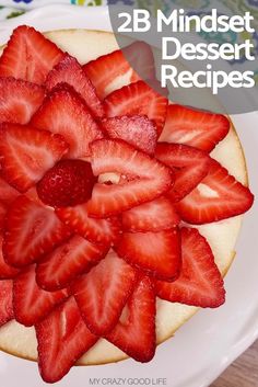 a white plate topped with a cake covered in sliced strawberries