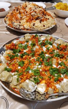 two platters filled with different types of food sitting on top of a dining table