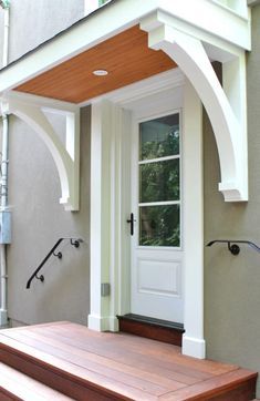 a house with a white front door and wooden steps