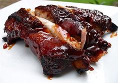 ribs covered in bbq sauce on a white plate