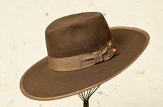 "1940s Wide Brim Western Hat Brown Beaver Fur Felt w/ Wide Rayon Band & Artisan Hat Pin  Chocolate brown beaver wool with wide rayon band & trim. Hat had been stretched to fit a larger head, rayon band had torn away from itself. Pin's had been placed to cover the gap perfectly (: A couple small holes as shown (could have been a part of the original boiling process?) This had is GORGEOUS. Measures 22.5\" around inside height: 4.5\" brim: 4\"" Vintage Fitted Felt Hat For Ranch, Vintage Fitted Fedora For Ranch, Fitted Vintage Fedora For Ranch, Vintage Fitted Hat For Ranch, Fitted Vintage Hat For Ranch, Vintage Fitted Hat Bands For Rodeo, Vintage Fitted Felt Hat For Western-themed Events, Fitted Vintage Felt Hat For Western-themed Events, Vintage Fur Felt Fedora For Fall