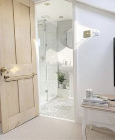 an open door leading to a bathroom with a sink and mirror on the wall in front of it