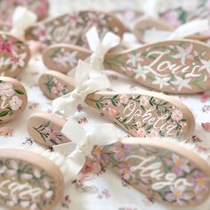 several wooden spoons decorated with flowers and the word love are on a white tablecloth