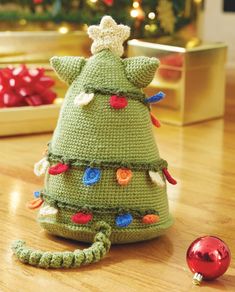 a crocheted christmas tree sitting on top of a wooden floor