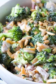 a bowl filled with broccoli and nuts on top of a table