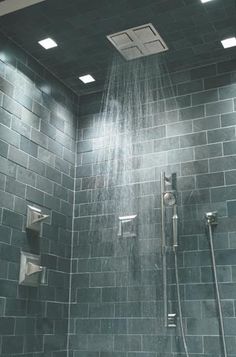 a shower head with rain coming out of it's side and lights on the ceiling