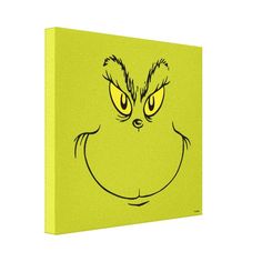 the grin face is drawn on a green canvas wall art print, with yellow eyes