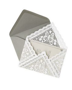 an open envelope with white lace on it