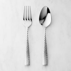 two forks and spoons sitting on top of a white countertop next to each other