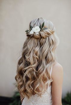 a woman with long blonde hair and flowers in her hair, wearing a white dress