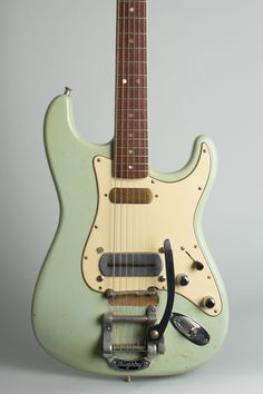 an electric guitar with a green body and pick up cable plugged into the neck