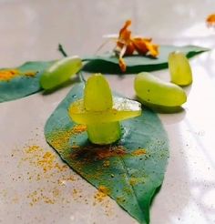 some green leaves and yellow flowers on a white tablecloth with orange sprinkles