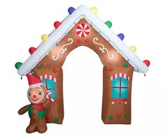 an inflatable gingerbread house is decorated with christmas lights and candy canes