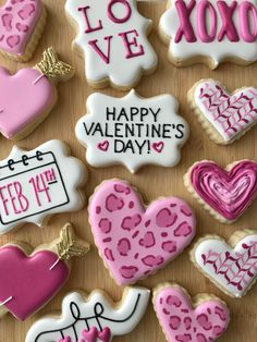 decorated cookies with valentine's day sayings and hearts are on a wooden surface