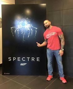 a man standing in front of a sign that says spectre with fireworks on it