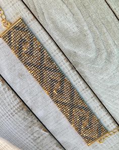 a gold chain bracelet sitting on top of a wooden table