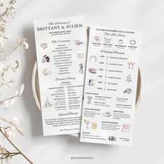 two white wedding program cards on top of a table next to some flowers and branches