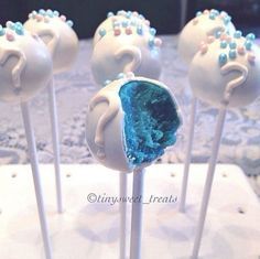 some white cake pops with blue frosting on them