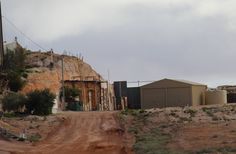 a dirt road that has some buildings on it