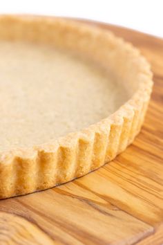 an uncooked pie crust sitting on top of a wooden cutting board