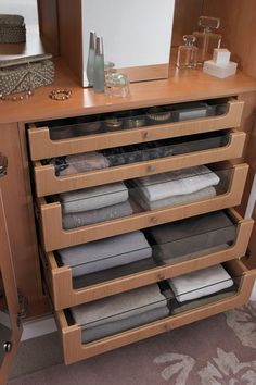 a wooden cabinet with drawers filled with folded towels