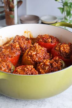 a green pot filled with meat and vegetables