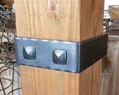 a close up of a wooden post with metal brackets