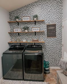 a washer and dryer in a small room with wallpaper on the walls