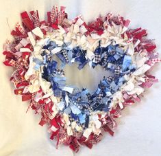 a heart shaped wreath made out of red, white and blue fabric