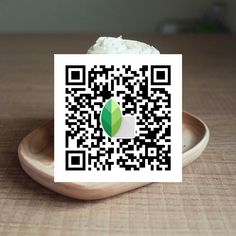 a piece of paper with a qr code on it sitting in a wooden bowl