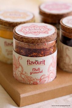 four jars filled with food sitting on top of a wooden tray next to each other