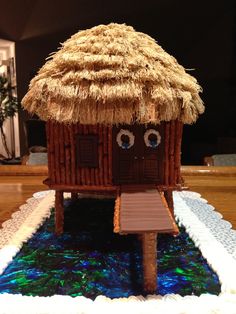 a cake made to look like a hut with two eyes and a straw roof on top