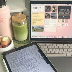 an open laptop computer sitting on top of a desk next to a cup of coffee