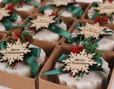 several soaps are wrapped in green ribbon and decorated with snowflakes, holly and red berries