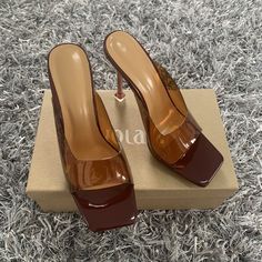 Complete your weekend vibe with these slip-on mules doll. Featuring a brown or red transparent color material with clear straps, these are sure to keep your weekend look effortlessly chic. Brown Slip-on Party Heels, Trendy Brown Open Toe Mules, Brown Slip-on Heels For Party, Brown High Heel Mules For Evening, Trendy Brown Open Heel Heels, Trendy Brown Peep Toe Heels, Chic Brown Heels For Date Night, Brown Mules For Party In Spring, Brown Mules For Summer Parties