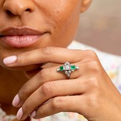 The Story A beautiful Art Deco dinner ring from the 1920s. At center is a half carat old mine cut diamond. Two square cut emeralds are bezel set above and below, each measuring 5 x 4.5 mm. Accenting the piece are eight old mine cut diamonds, each 0.07- 0.08 carats, giving the ring a total diamond weight of approximately 1.12 carats. The back is completely open allowing the diamonds to sparkle bright and the emeralds to pop with color. Measuring just under an inch tall, the shape and size has a substantial feel. The 18k white gold design allows for open work and millegrain detailing throughout. Worn as an engagement ring or a cocktail ring, this beautiful piece is sure to stop you in your tracks. The Specs Style Number: R2533 Antique, circa 1920s 18 karat white gold 2 square cut emeralds, e Heirloom Emerald-cut Ring With Single Cut Diamonds, Heirloom Emerald Cut Ring With Single Cut Diamonds, Art Deco Emerald Cut Diamond Jewelry, Art Deco Emerald Diamond Ring For Wedding, Art Deco Emerald Cut Platinum Jewelry, Art Deco Emerald And Diamond Wedding Ring, Art Deco Emerald Ring With Diamond As Gift, Art Deco Emerald Ring With Diamond For Gift, Art Deco Emerald Ring With Round Cut In Platinum