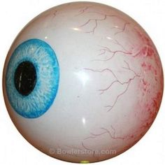 an eyeball with blue and red markings on it sitting on top of a wooden floor