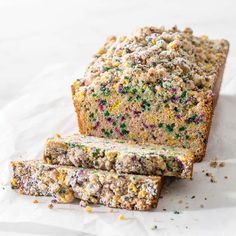 a loaf of cake with sprinkles sitting on top of white parchment paper