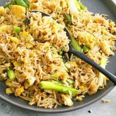 a plate full of rice and asparagus with a spoon in it on a table