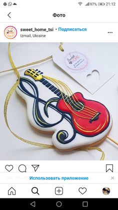 a decorated cookie with a guitar on it's side, and the words doro written in russian