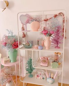 a shelf filled with vases and other items on top of white shelve